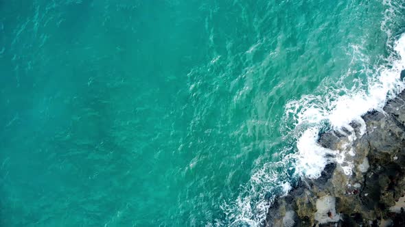 View from the top as ocean waves break on the rif