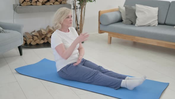 Senior Old Woman Doing Stretches on Yoga Mat at Home alt