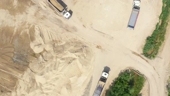 Aerial view, machinery working at clay quarry, heavy loaders, large trucks, bulldozers, excavators, alt