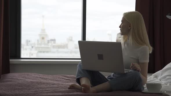 Happy Blonde Woman with Laptop Talking on Video Call with Her Girlfriend
