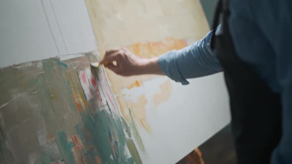 Creative Person at Work a Talented Artist Covers the Canvas with Graybeige Oil Paint Priming and alt