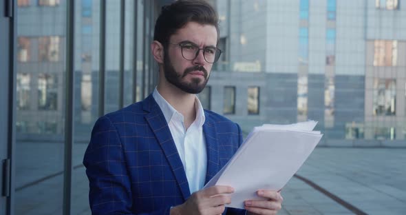 Portrait Businessman Looking at Papers alt