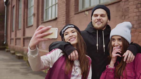 Group of young hipster friends make selfie photo with smartphone camera