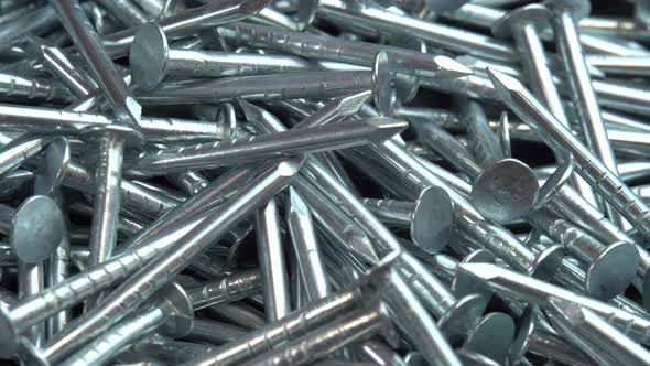 Metal Steel Nails for Construction Work Falling on a Rotating Surface Hobnails are Spinning Close Up alt
