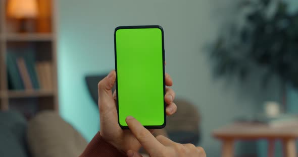 Close Up of Man Sliding with on Green Screen of Smartphone