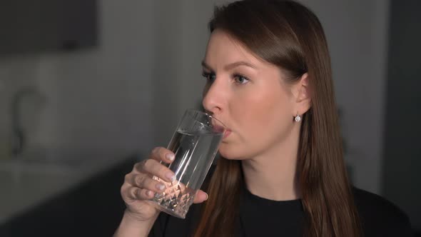 A Young Woman is Holding a Glass of Clean Water