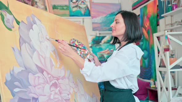 Woman Artist Working with the Big Painting at Workshop