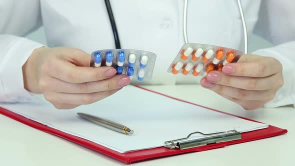 Female Physician Comparing Medications in Blister Packs, Writing, Doing Research alt