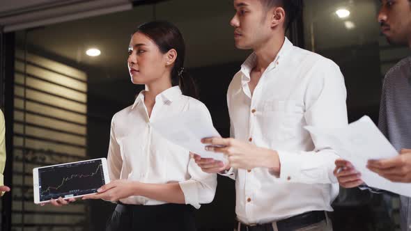 Asian young business people group brainstorming and working on discussion meeting in office at night alt