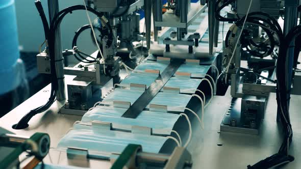 Pressing Conveyor and Medical Masks Moving Along It alt