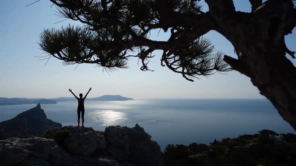 Sporty Girl Climbed To the Top of the Cliff and Enjoying the View of the Sun and Sea. Young Woman alt