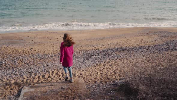 Young Girl in a Coat Rejoices in the Sea