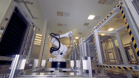 Future Concept, Automated Robotic Arm Is Moving, Taking a Large Metal Plate and Putting It Down. alt