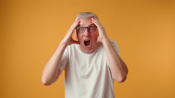 Mature Elderly Man Screaming Loud Against Yellow Background