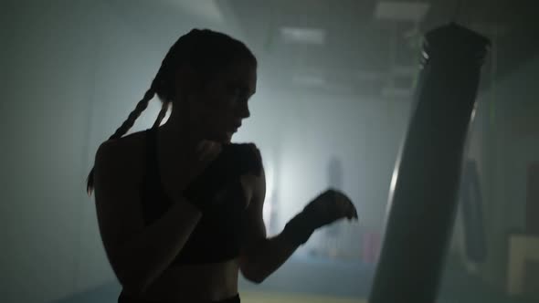 Caucasian Woman Fighter Trains His Punches and Defense in the Boxing Gym Contour Lighting Slow alt