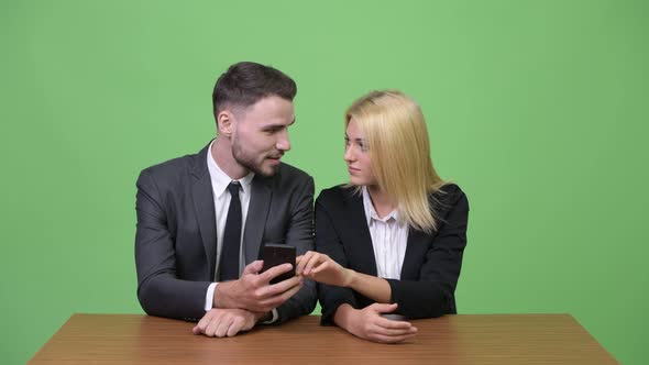 Young Happy Business Couple Using Phone Together