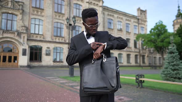 Medium Shot Portrait of Self Assured Elegant African American Man in Suit with Attache Case Standing alt