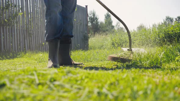 Male Gardener Mowing Green Lawn with Manual Gas Grass Mower Garden Maintenance alt