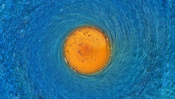 Motion graphics aerial top view of round island middle of moving ocean. Cinema graphics endless loop alt