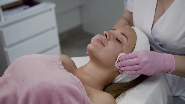 Pretty Woman Having Cleansing the Skin with Swabs During Cosmetology Treatment alt