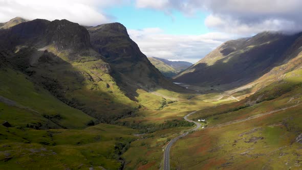 Scenic drone view of a road winding through highlands in Scotland near Glenco