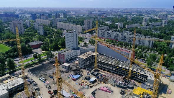 Flying over construction site. Top view of yellow tower cranes. Drone footage alt