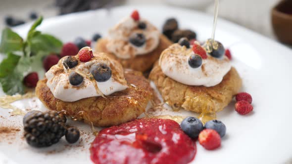 Pouring Honey On Curd Fritters, Syrniki Pancakes For Breakfast. Closeup. alt