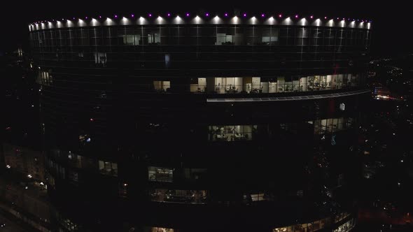 Aerial View From Drone on Glass Facade of Modern Skyscraper with Offices at Night alt