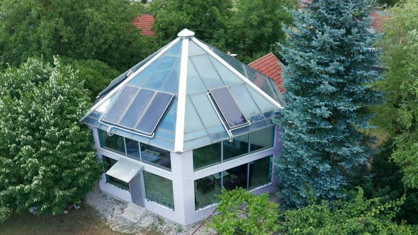 Glass roof with panels and transparent walls of a solar, energy efficient house, with hexagonal base alt