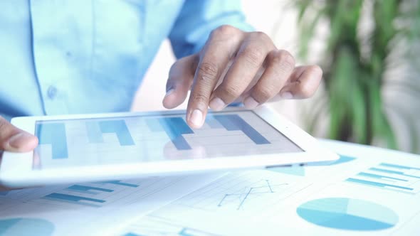 Man's Hand Working on Digital Tablet at Office Desk Using Self Created Chart alt
