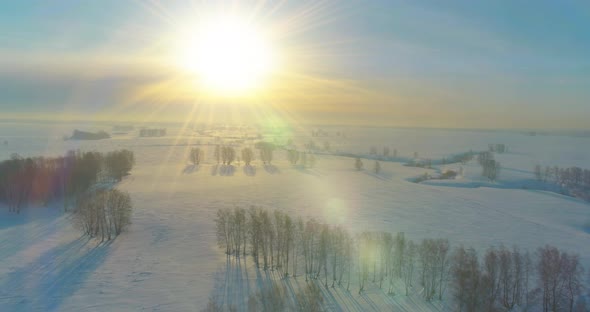 Aerial View of Cold Winter Landscape Arctic Field Trees Covered with Frost Snow Ice River and Sun alt