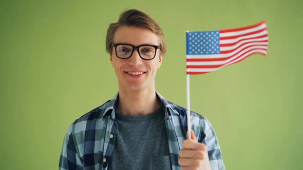 Slow Motion Portrait of Young Man with American National Flag Smiling alt