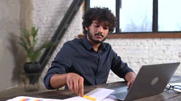 Front View of Positive Hindu Man in Smart Casual Shirt Using Laptop