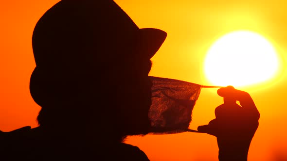 Guy Puts Medical Mask on His Face on Sunny Morning. Silhouette a Young Man Putting On a Protective