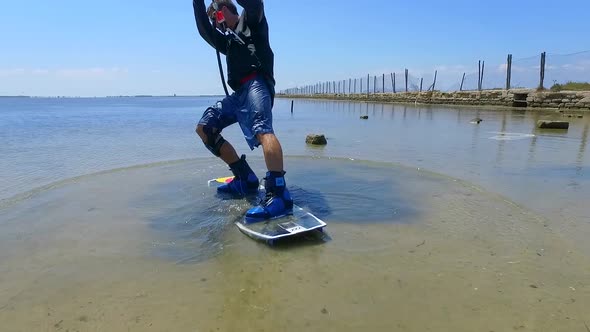 Aerial drone view of a man kiteboarding on a kite board alt