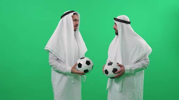 Two Arab Men in Traditional Clothes on the Background of a Chroma Key Mans Wearing Kanduras and Hold alt