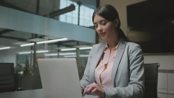 Young Confident Business Lady in Formal Wear Typing on Laptop at Workplace Making Project for alt