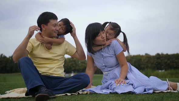 Lovely Asian Family with Siblings Relaxing at Park alt
