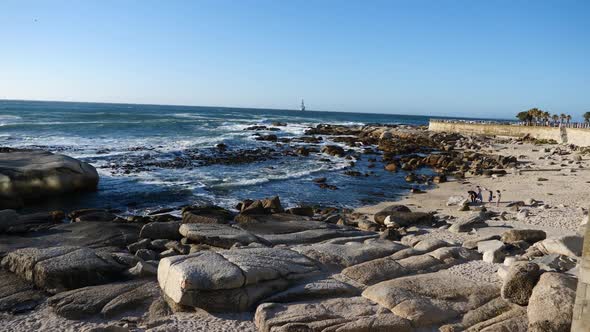 Wide shot of Bantry Bay, South Africa in late afternoon sunlight on a blue sky day at the Atlantic O alt