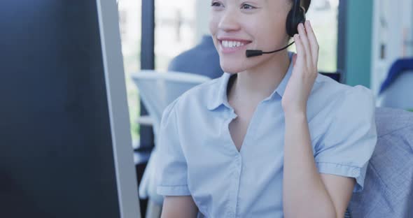 Young woman with headset working on computer alt