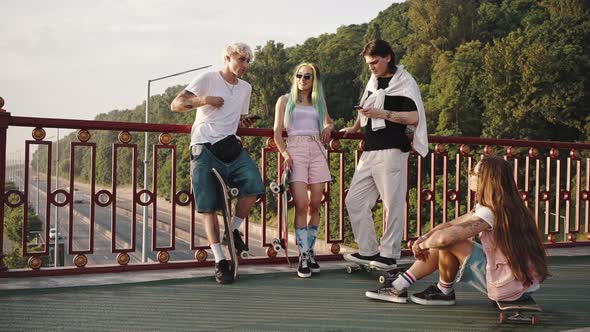 Group of Teens Making Activities in Urban Area Meeting and Socializing Skateboarding on Summer alt