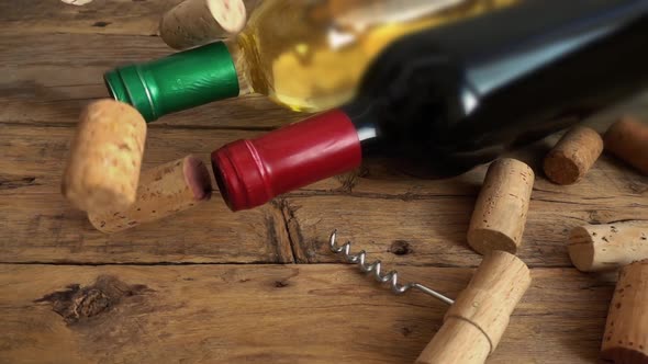 Wine bottles on an old vintage wooden board and falling corks. Slow motion. alt