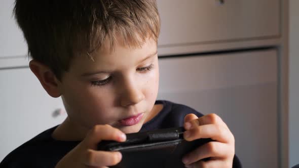 Boy Playing Video Game on Mobile Phone. Young Hacker. Cyber Security Background. Child and Gadget