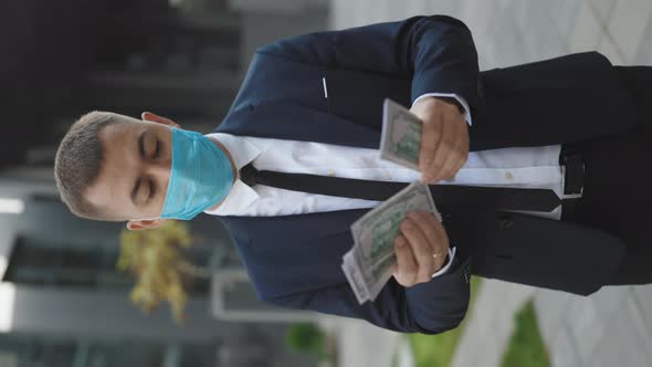 Cheerful Rich Handsome Businessman in Protective Face Mask Counting Money alt