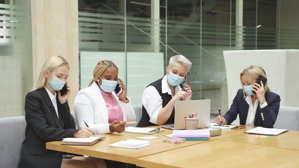 Team of Mixed Race Colleagues Talking on Phone in Office. alt
