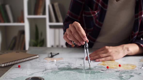 A Woman Traveler Makes Measurements On A Map To Determine The Distance, A Route Plan alt