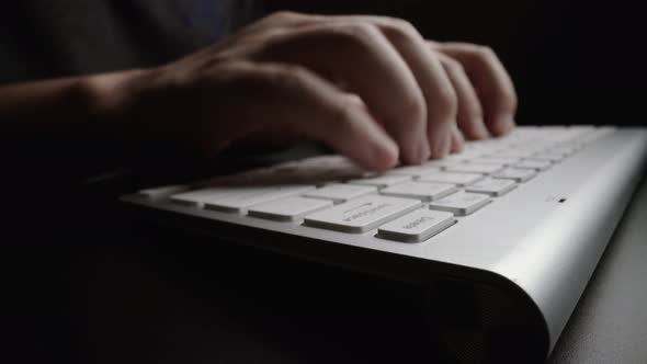 Close-up typing on keyboard with man fingers. Macro soft focus dolly shot. alt