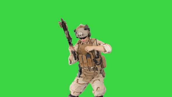 Soldier Shooting with Assault Rifle and Reloading on a Green Screen, Chroma Key. alt