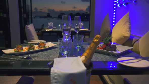 A luxury fine dining table dinner setting with champagne and meals served. alt