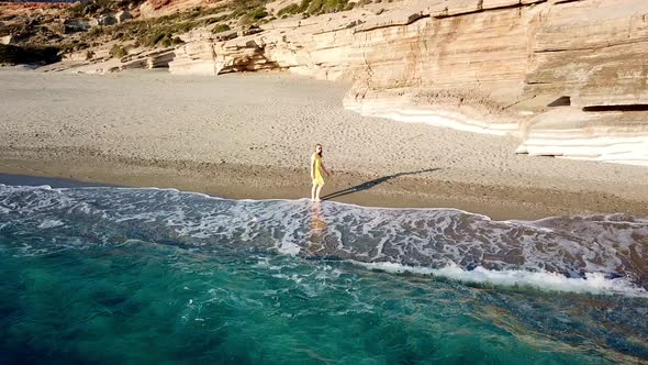 Aerial Drone Footage of a Girl Walking Along a Lonely Beach